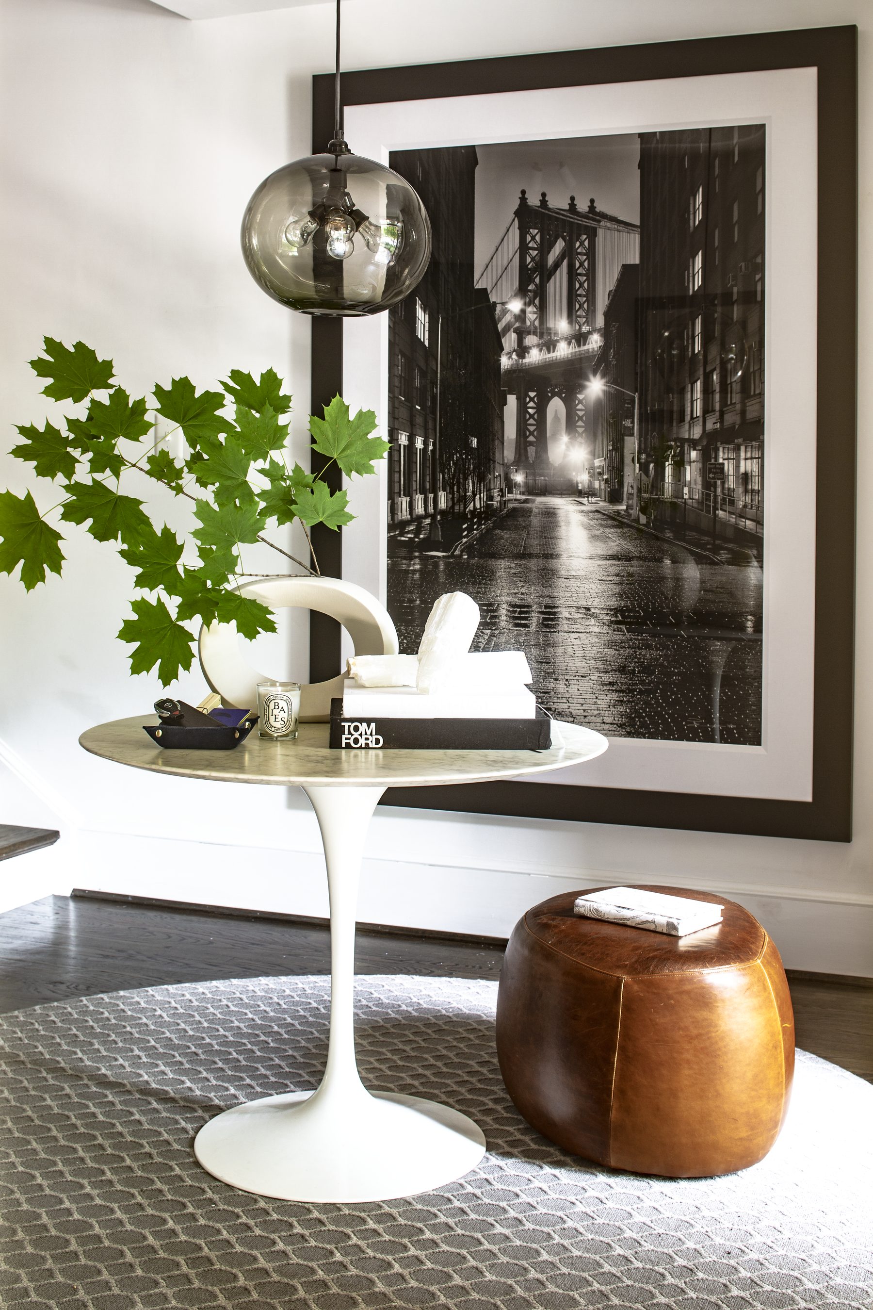 Tulip table and leather pouf beneath a large black-and-white photograph — Cleveland Park Residence by Christopher Patrick Interiors