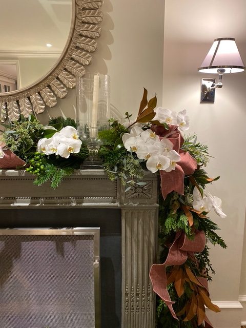 Mantel garland with white orchids, magnolia, and blush ribbon — holiday decorating by Christopher Patrick Interiors