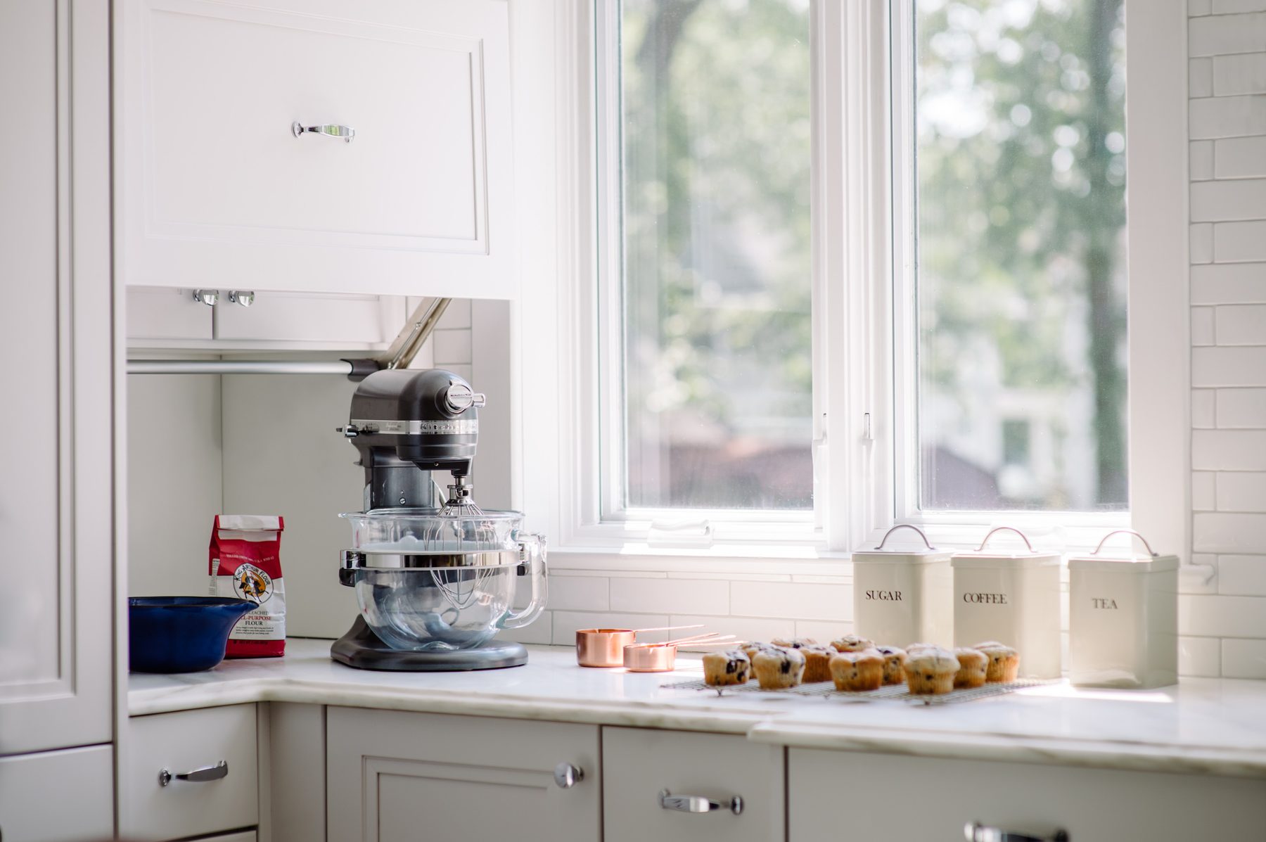 White kitchen with Blue Lagoon navy island and unlacquered brass — the Southern Living kitchen by Christopher Patrick Interiors, Washington, DC